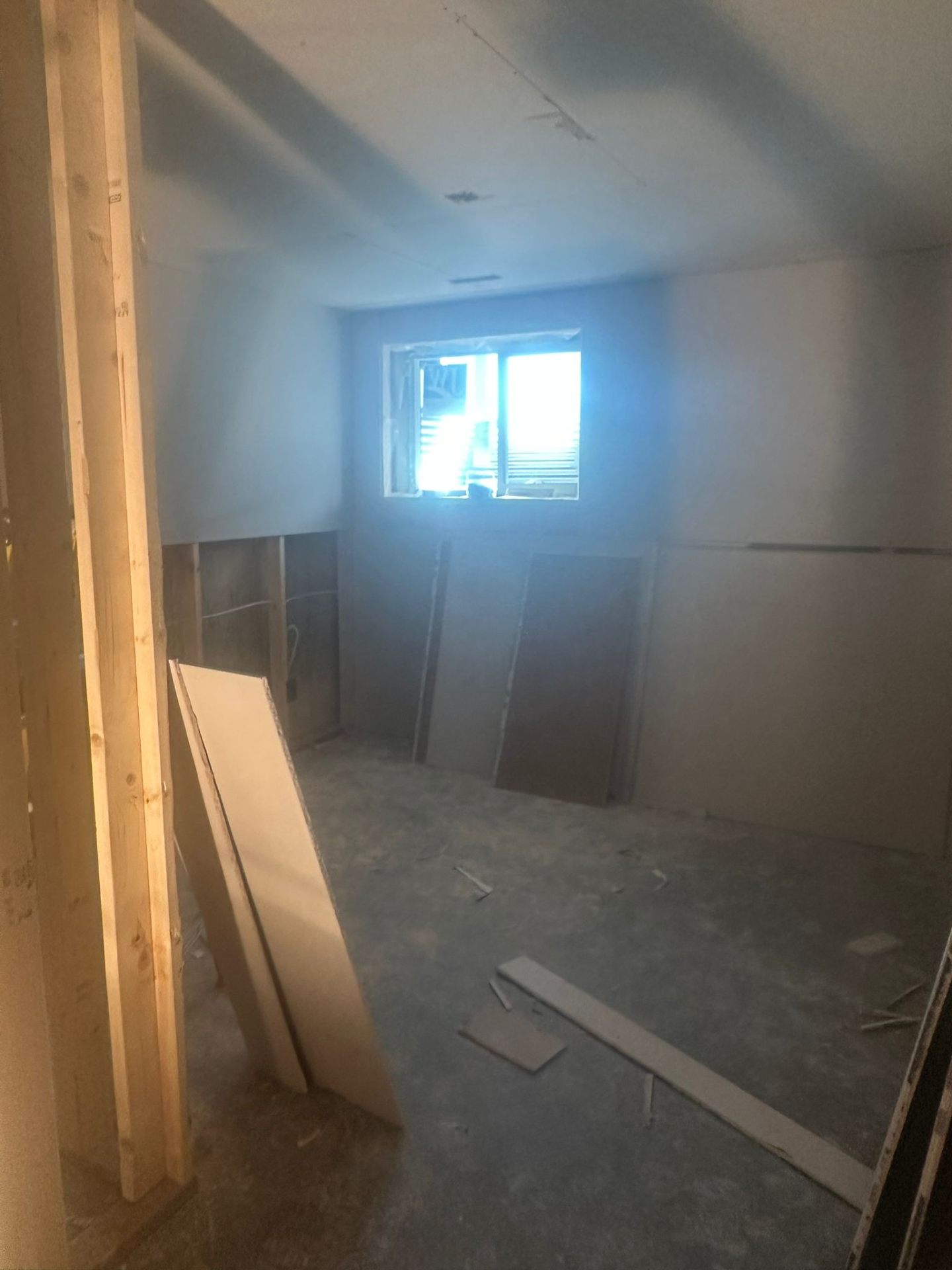 Basement bedroom framed and drywalled with new egress window letting in natural light
