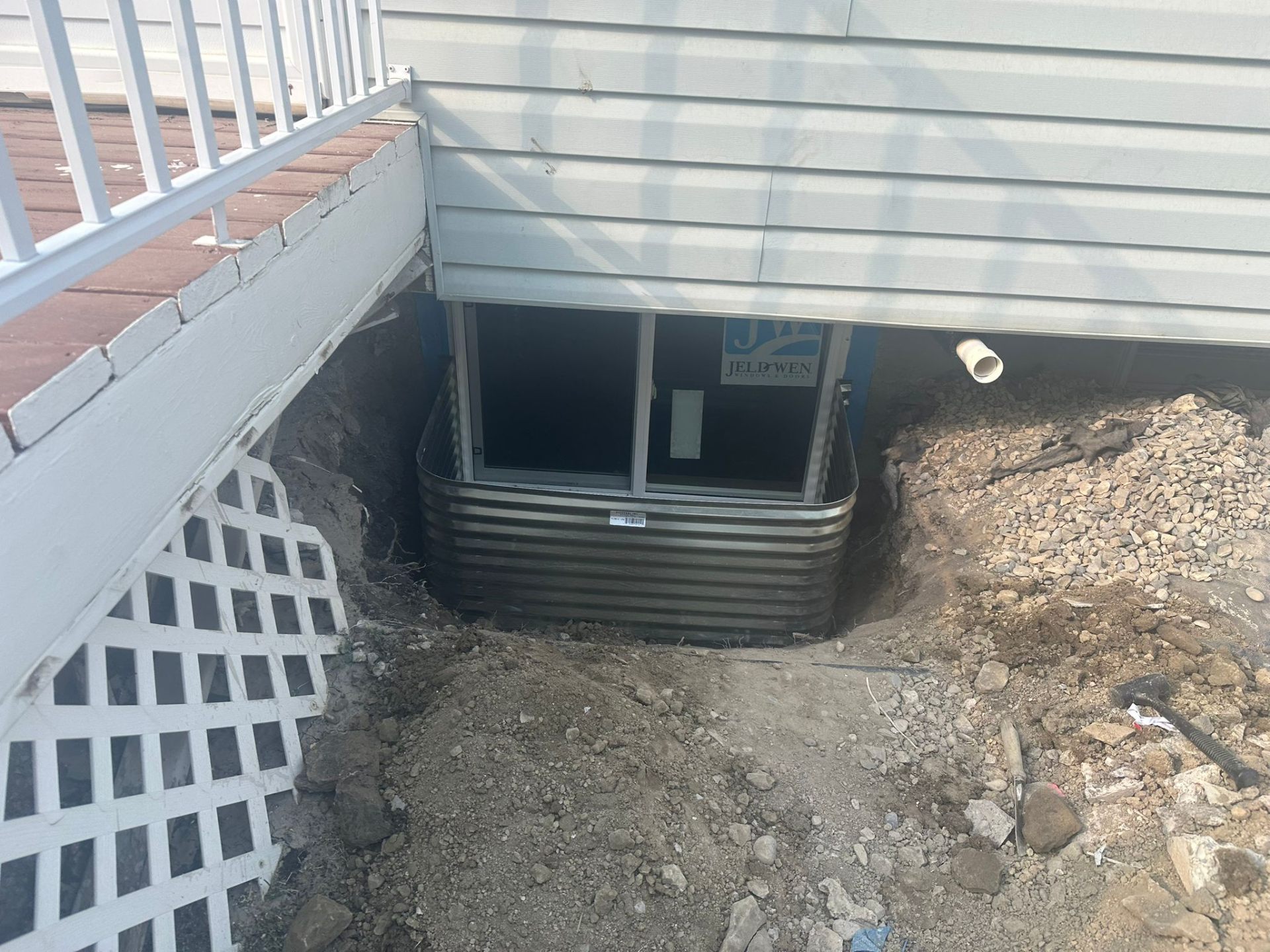 New JELD-WEN basement egress window installed with corrugated well from outside