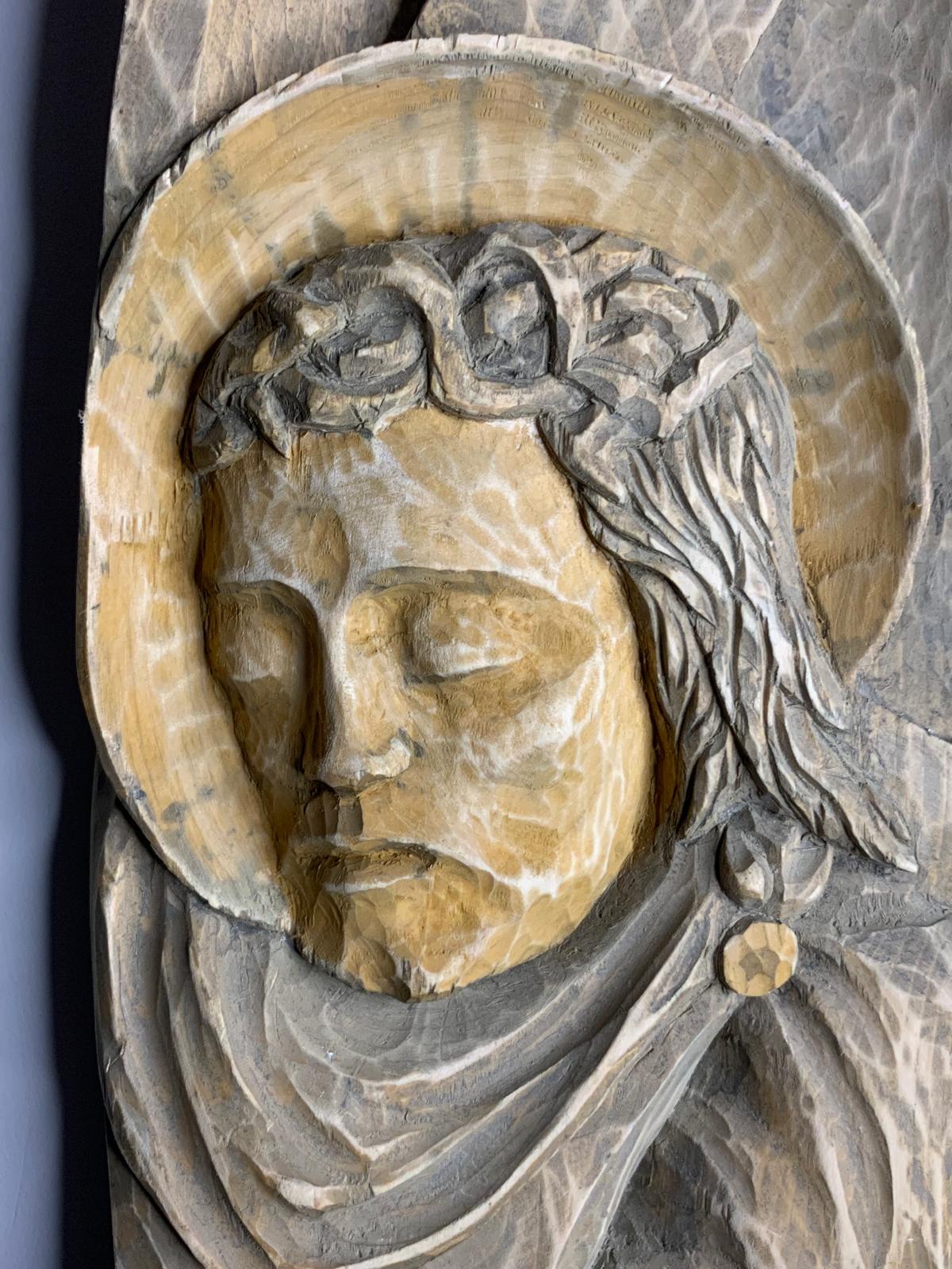 Detail of carved haloed saint with hand-chiseled tool marks